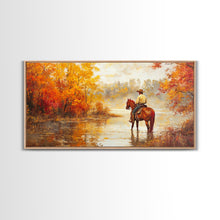 Load image into Gallery viewer, Cowboy sitting by campfire near a lake in the woods with autumn leaves, Framed Canvas Print, moody fall wall art, rustic western home decor