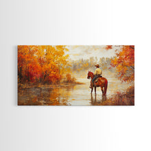 Load image into Gallery viewer, Cowboy sitting by campfire near a lake in the woods with autumn leaves, Framed Canvas Print, moody fall wall art, rustic western home decor