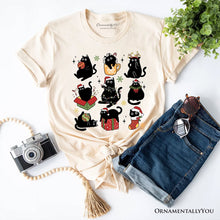 Cargar imagen en el visor de la galería, Christmas Black Cats T‑Shirt, Whimsical Cats with Santa Hat Tee