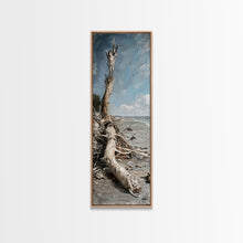 Carregar imagem no visualizador da galeria, Framed Canvas Print Skinny Art of a Weathered Driftwood Tree Trunk on a Sandy Shore with a Calm Ocean Backdrop, Ideal Tall Art for Coastal Decor
