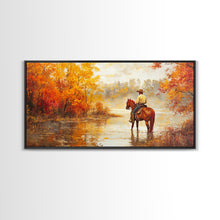 Load image into Gallery viewer, Cowboy sitting by campfire near a lake in the woods with autumn leaves, Framed Canvas Print, moody fall wall art, rustic western home decor
