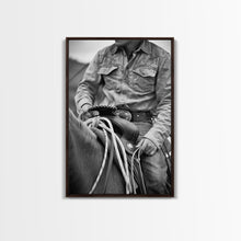 Load image into Gallery viewer, Close-up of cowboy hands holding reins, detailed Western art, black and white photography, Framed Canvas Print, rustic home decor, wall art
