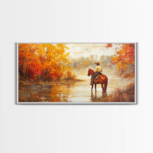 Load image into Gallery viewer, Cowboy sitting by campfire near a lake in the woods with autumn leaves, Framed Canvas Print, moody fall wall art, rustic western home decor
