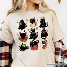 Cargar imagen en el visor de la galería, Christmas Black Cats T‑Shirt, Whimsical Cats with Santa Hat Tee
