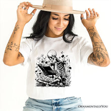 Load image into Gallery viewer, Gothic Reading Skeleton T-Shirt, Floral Halloween Tee for Spooky Bookworms

