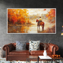 Load image into Gallery viewer, Cowboy sitting by campfire near a lake in the woods with autumn leaves, Framed Canvas Print, moody fall wall art, rustic western home decor
